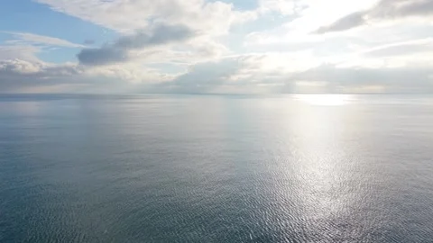 Dramatic cloudscape over calm sea with mirror reflections and horizon Video stock 327840314