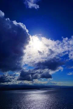 Dramatic Cloudscape Over the Sea With Sunlight Reflection Stock Photos