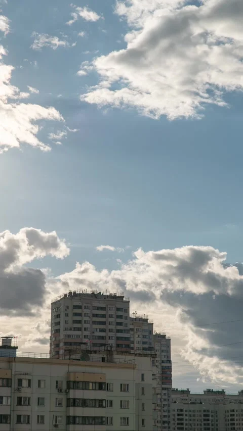 Dramatic Cloudscape Over Urban High-Rise Apartments With Blue Sky and Soft Sunli Stock Footage 335661151