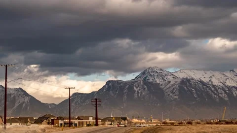 With a dramatic cloudscape overhead, traffic speeds along the highway in Stock Footage 146618732
