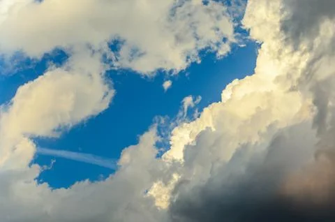 Dramatic cloudscape scene, colored sun lights on the blue sky, fluffy clouds Stock Photos