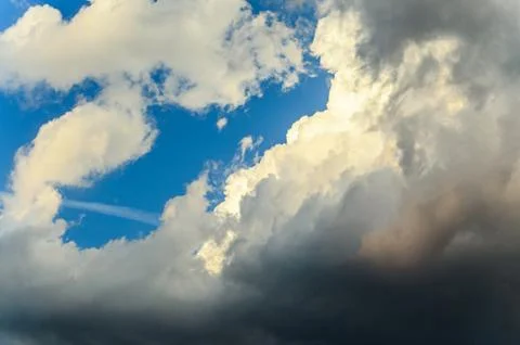 Dramatic cloudscape scene, colored sun lights on the blue sky, fluffy clouds Stock Photos