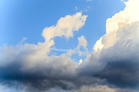Dramatic cloudscape scene, colored sun lights on the blue sky, fluffy clouds Stock Photos