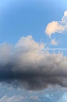 Dramatic cloudscape scene, colored sun lights on the blue sky, fluffy clouds Stock Photos