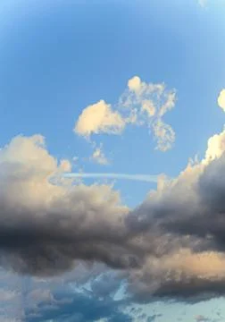 Dramatic cloudscape scene, colored sun lights on the blue sky, fluffy clouds Stock Photos
