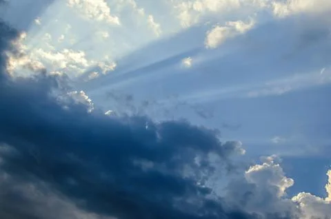 Dramatic cloudscape scene, colored sun lights on the blue sky, fluffy clouds Stock Photos