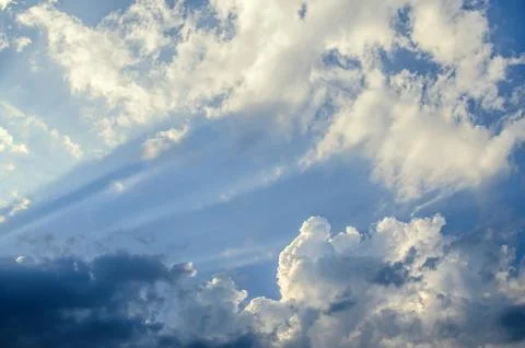 Dramatic cloudscape scene, colored sun lights on the blue sky, fluffy clouds Stock Photos