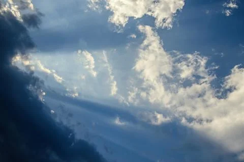 Dramatic cloudscape scene, colored sun lights on the blue sky, fluffy clouds Stock Photos