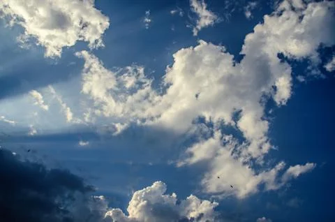 Dramatic cloudscape scene, colored sun lights on the blue sky, fluffy clouds Stock Photos