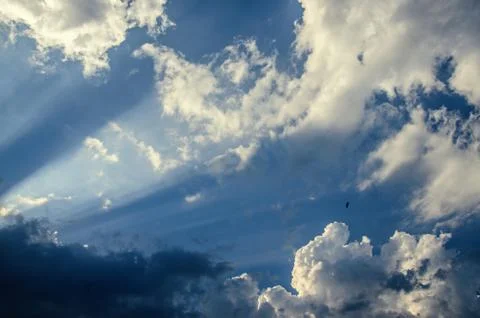 Dramatic cloudscape scene, colored sun lights on the blue sky, fluffy clouds Stock Photos