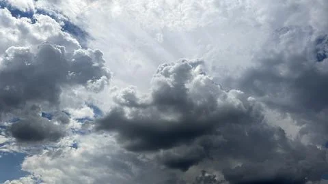Dramatic Cloudscape with Sunbeams Breaking Through Cumulus Clouds Stockfoto's