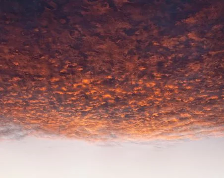 Dramatic cloudscape at sunset with red clouds on sky Stock Photos