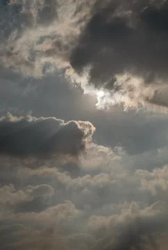 A dramatic cloudscape unfolds, with dark, heavy clouds as bright sunlight p.. Stockfoto's