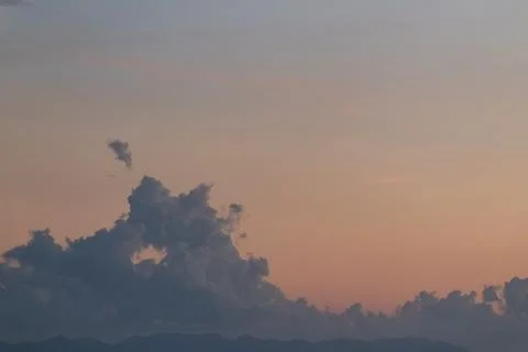 Dramatic cloudscape with vibrant orange and pink sky at dusk, creating a sere Stock Photos