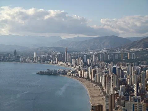 Dramatic Cloudy Horizon With Towering Buildings And Scenic Mountain Backdrop Fotos de archivo