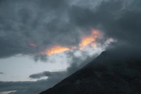 Dramatic Cloudy Sky and Glowing Evening Sky Over Mountain Peak. Stock Photos