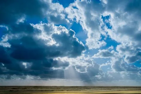 Dramatic cloudy sky and suns rays over sea  at Bayleys beach in Northland Foto stock