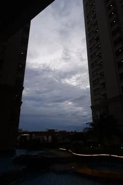 Dramatic Cloudy Sky Framed Between Silhouetted Apartment Towers at Dusk Stock Photos