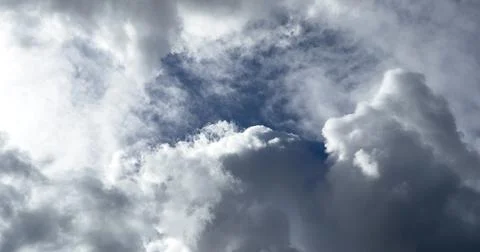 Dramatic cloudy sky with large white cloud formations and blue openings. Brig Stock Photos