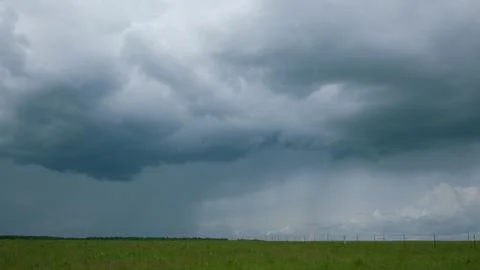 A Dramatic Cloudy Sky Looms Over Vibrant Green Fields, Creating a Stunning Visua Stock Photos