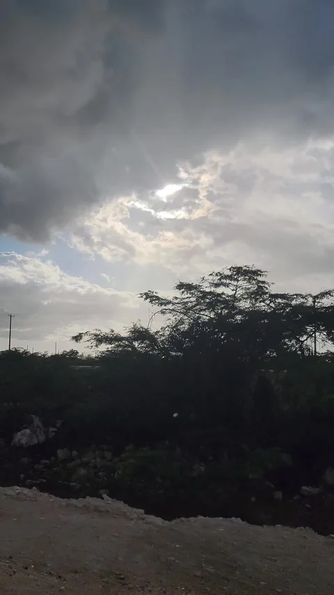 Dramatic cloudy sky over asphalt road with sun breaking through clouds 4K Stock Footage 329073155