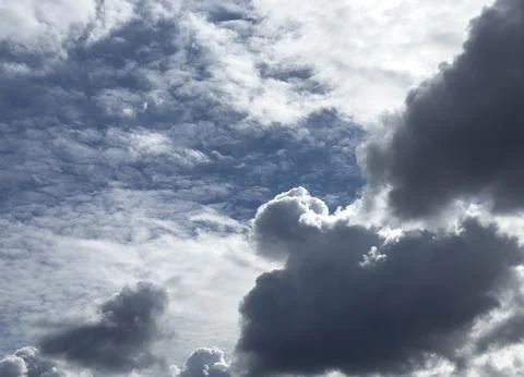 Dramatic cloudy sky over blue background. Dark storm clouds and bright light  Foto stock