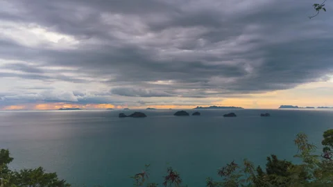 Dramatic Cloudy Sky over Calm Sea with Small Islands on Horizon during Golden Stock Footage 319278442