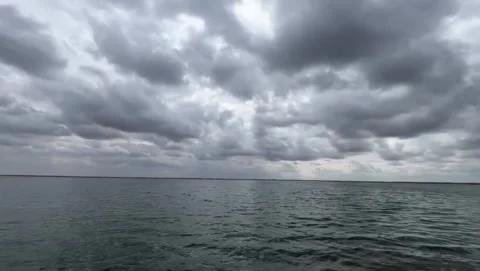 Dramatic cloudy sky over a calm lake or ocean horizon Vídeos de archivo 334085016