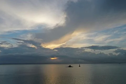 Dramatic Cloudy Sky Over Calm Sea with Rock Outcrop and Lighthouse, China Stock Photos