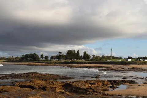 Dramatic Cloudy Sky Over Coastal Landscape With Rocky Shore At Sunset Stock Photos