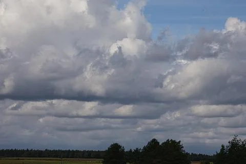 Dramatic cloudy sky over a distant forest and fields Stock Photos