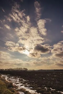 Dramatic cloudy sky over the early spring landscape with field Stock Photos