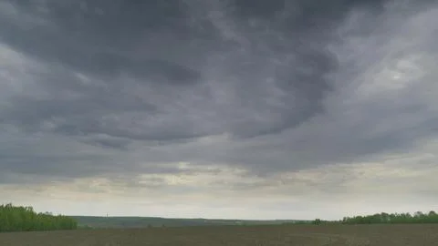 A Dramatic Cloudy Sky Over An Expansive Open Field Landscape That Captivates the Stock Photos