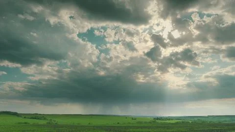 A Dramatic Cloudy Sky Over an Expansive Green Landscape Captivates the Imaginati Stock Photos