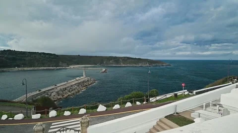 Dramatic cloudy sky over the Luarca harbor in an slow motion zoom out day scene. Video stock 322046094
