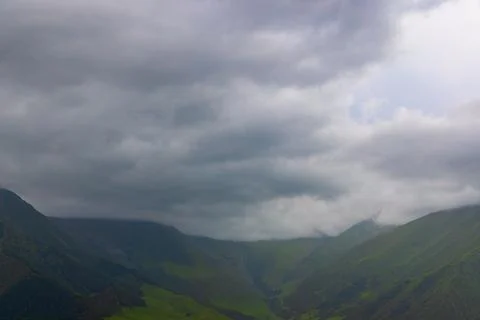 Dramatic Cloudy Sky Over Lush Green Mountain Valleys 스톡 사진