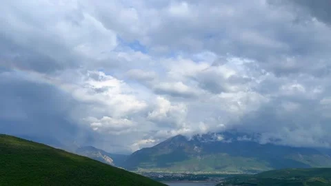 Dramatic cloudy sky over mountain landscape with soft sunlight breaks Stock Footage 310246014
