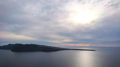 Dramatic cloudy sky over the Santorini caldera and Aegean Sea with sun rays Stock Photos