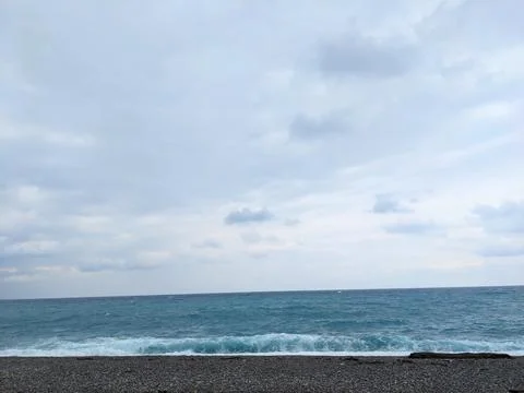 Dramatic cloudy sky over the turquoise Pacific Ocean waves on a Hualien pebble Stock Photos