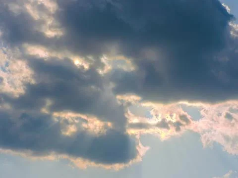 Dramatic cloudy sky with sunbeams breaking through the clouds. Stock Photos