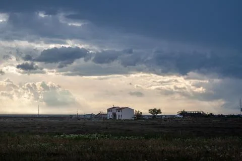 Dramatic cloudy stormy sky over two houses seaside Stock Photos