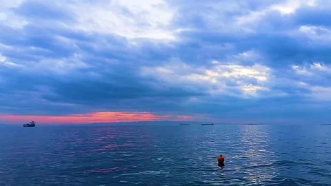 A dramatic, cloudy sunset over the sea, with the horizon visible from the Sarkoy Stock Footage 323209860