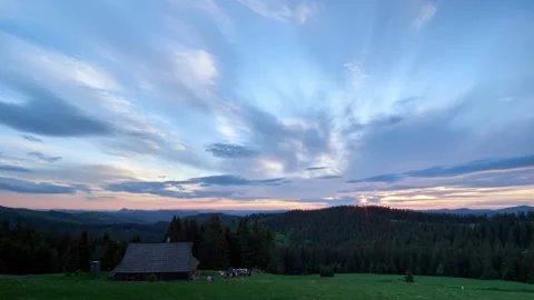 Dramatic cloudy sunset. People camp in the middle of the forest in a wooden hut Stock-Footage 195644899