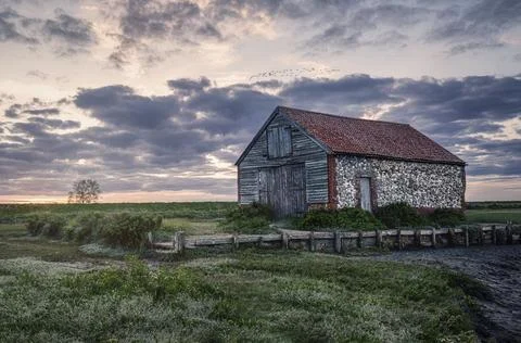 Dramatic cloudy sunset at Thorham Barn Stock Photos