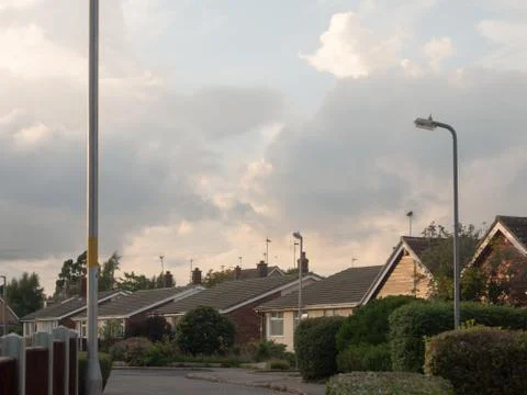 Dramatic cloudy white skies above village scene in england during sunset Foto stock