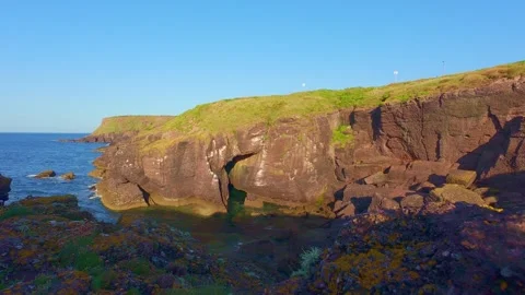 Dramatic coastal cliff edge and calm ocean horizon under clear sky in ireland Stock Footage 340433302