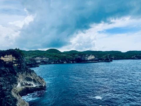 Dramatic Coastal Cliffs and Blue Ocean under Stormy Sky Stock Photos