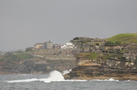 Dramatic coastal cliffs and crashing waves near Sydney on a cloudy day. Foto stock