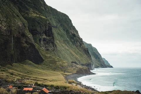 Dramatic Coastal Cliffs and Serene Ocean Waves Under a Cloudy Sky, Small Vi.. Stock Photos