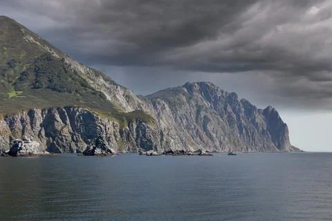 Dramatic coastal cliffs and storm clouds on the Kamchatka Peninsula seascape Stock Photos